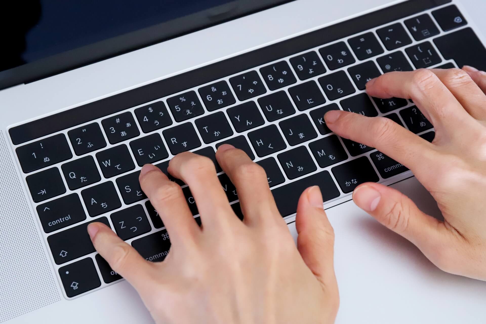 ノートパソコンでタイピングする手元